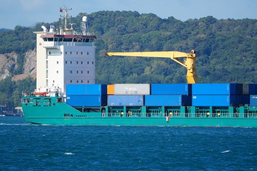 Free Large container ship sailing through the Istanbul Bosphorus on a sunny day with green hills in the background. Stock Photo