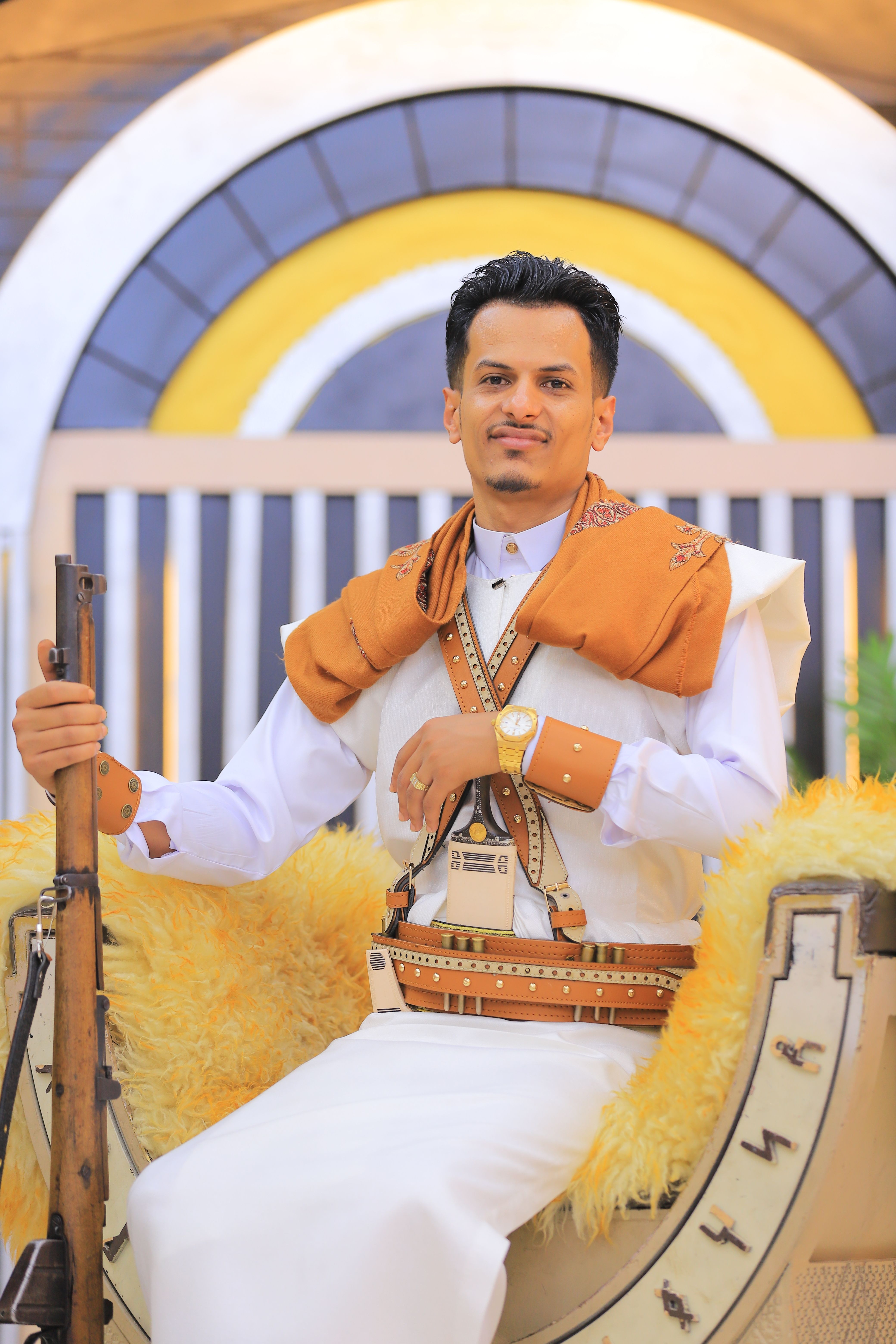 Man in traditional Middle Eastern attire with intricate details and colorful patterns.
