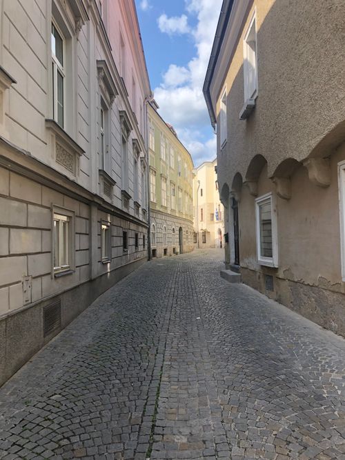 Free A picturesque cobblestone street lined with historical buildings in a quaint Austrian town during the day. Stock Photo