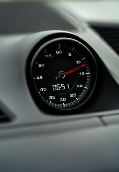 Close-up view of a modern car's speedometer showing time with a sleek design.