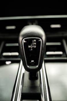 Detailed view of a sleek black car gear shifter in a luxury vehicle interior.