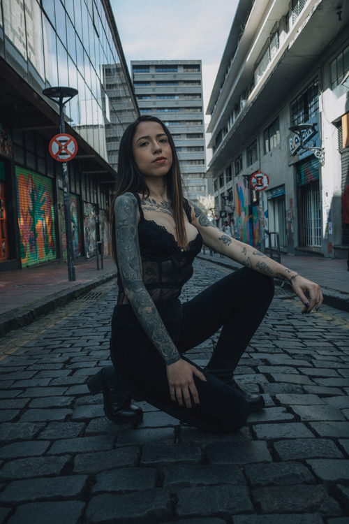 Free Stylish tattooed woman poses in an urban street with graffiti. Stock Photo