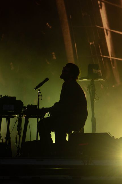 Keyboard player silhouetted in green stage light — photo by Eddie Stofe on Pexels