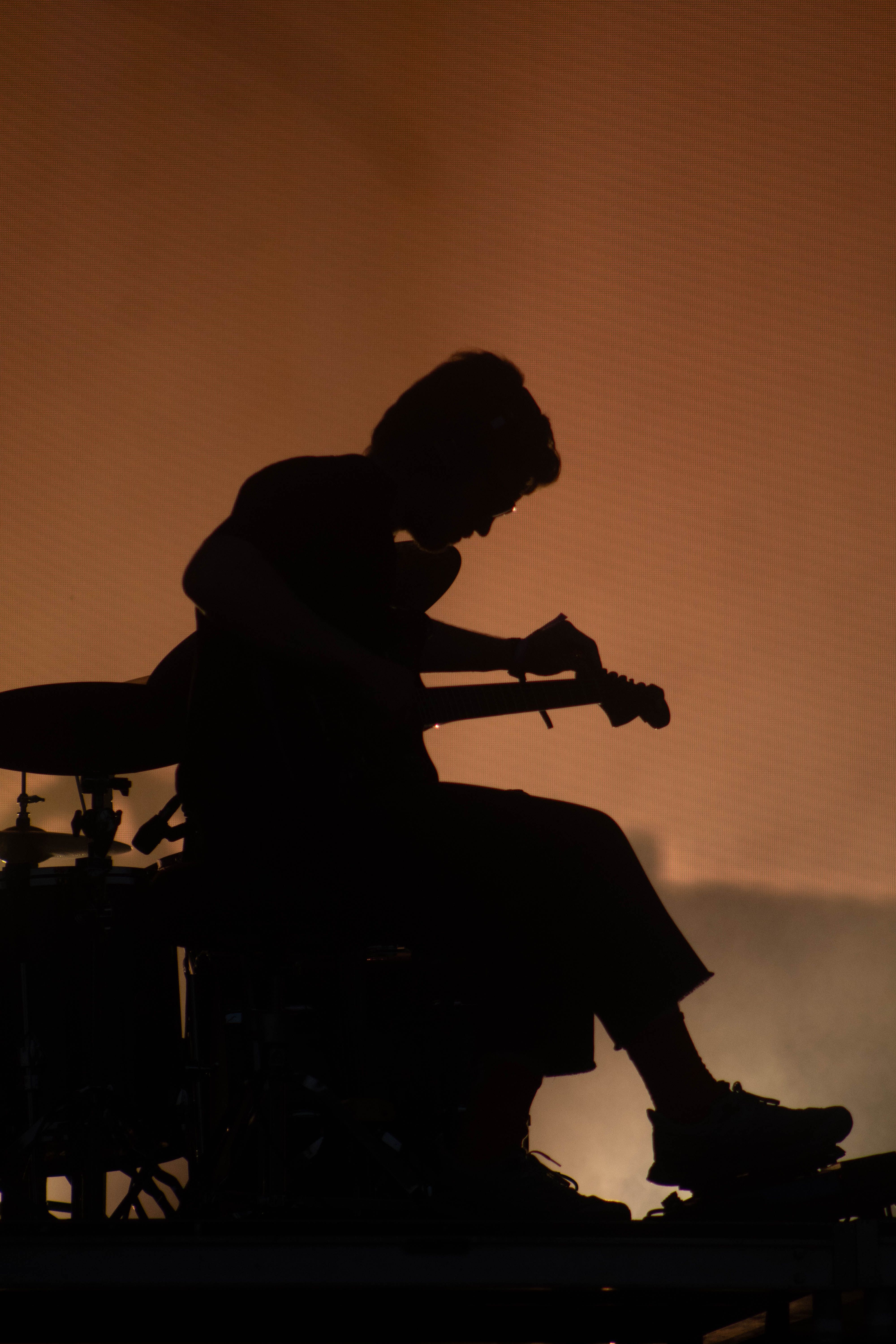 Gratis Silhouette spettacolare di un chitarrista che si esibisce dal vivo sul palco, con un'intensa retroilluminazione. Foto a disposizione