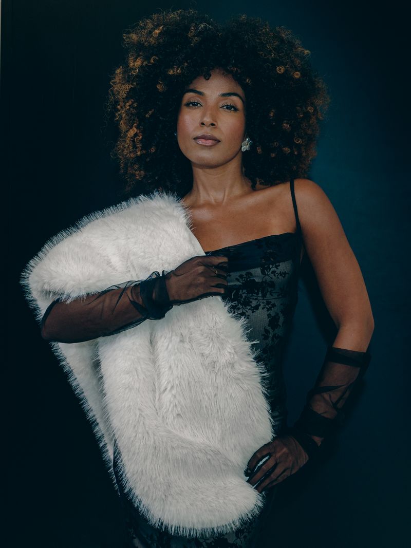 woman in ivory faux fur coat over black dress