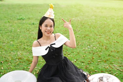Free Smiling woman in party hat celebrates birthday outdoors on a sunny day. Stock Photo