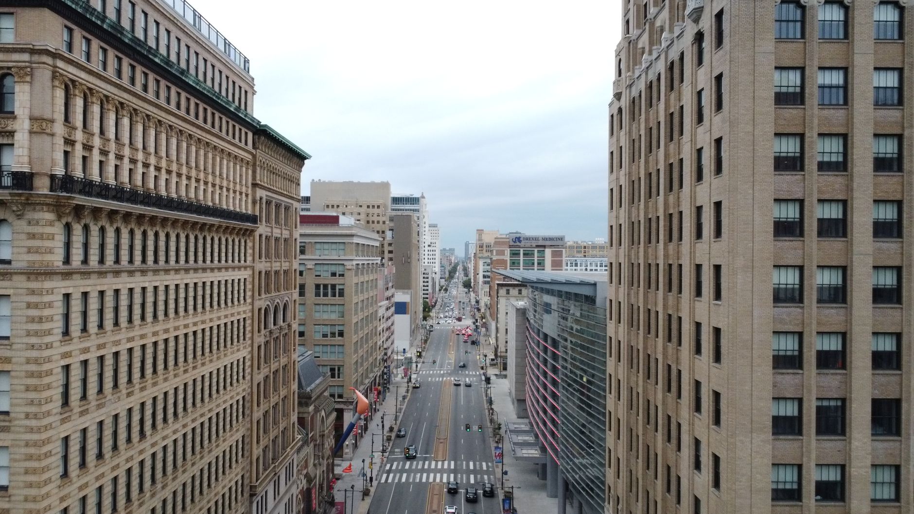 Aerial cityscape of downtown Philadelphia showcasing historic and modern architecture under a cloudy sky.