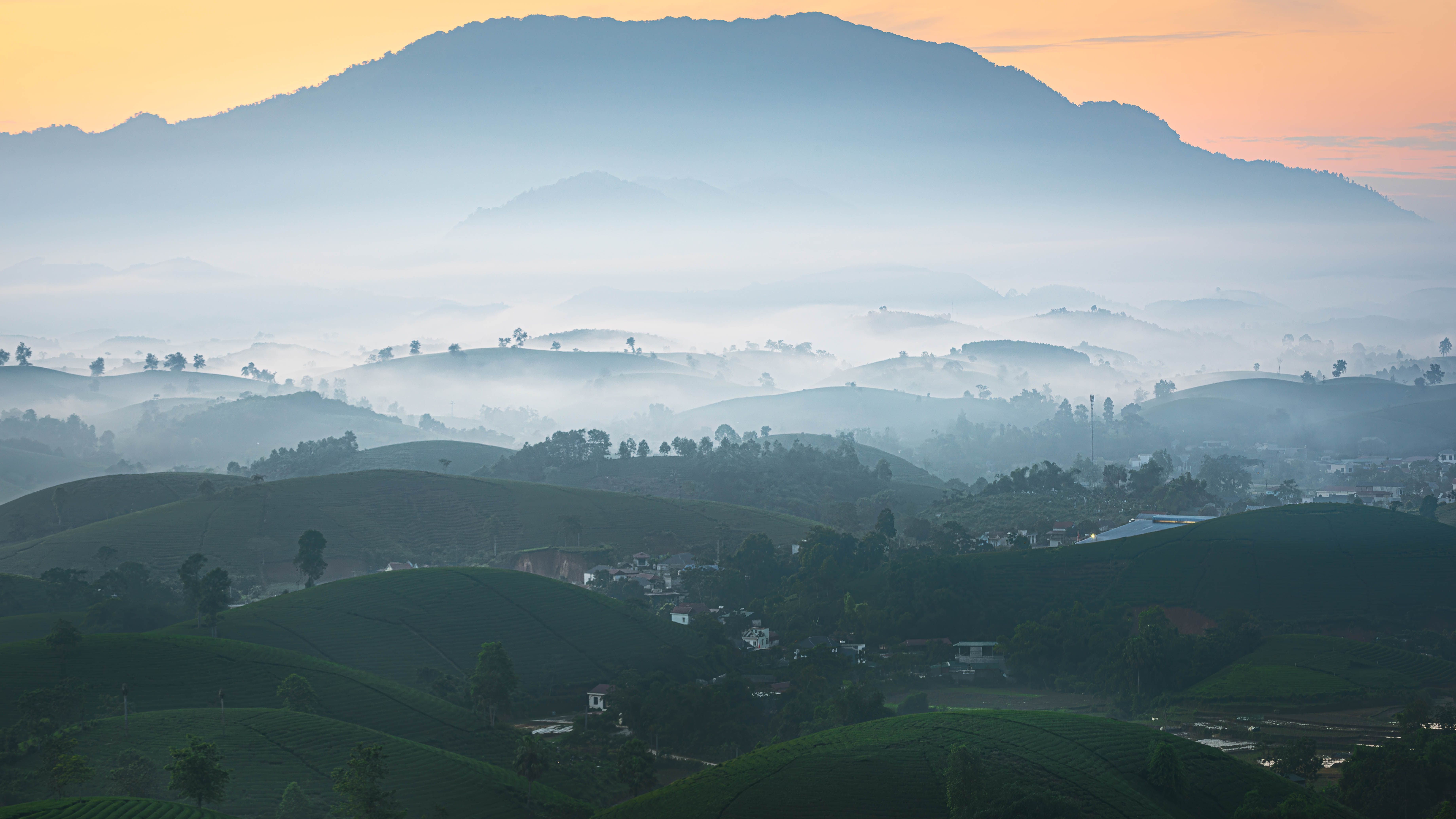 A peaceful misty mountain view with rolling hills and sunrise hues.. peaceful, misty, mountain