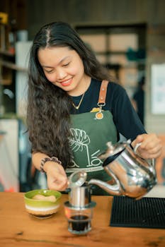 A smiling barista skillfully brews fresh coffee at a cozy café. Perfect lifestyle shot.
