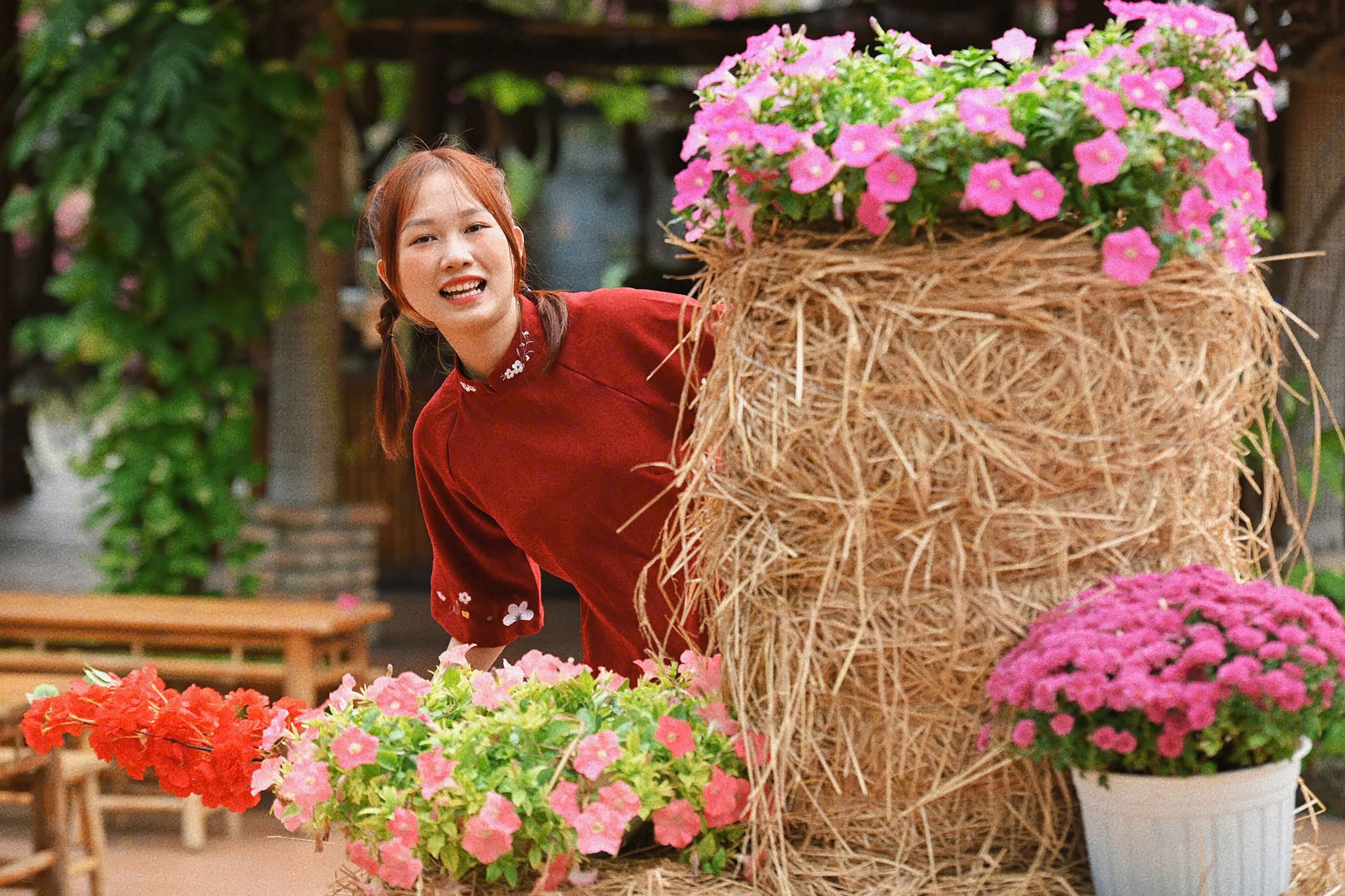 A Vietnamese woman in a traditional ao dai dress enjoying a vibrant spring setting with flowers.