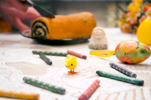 Yellow Chick Toy Surrounded by Assorted-color Crayons on Table Top