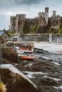 View of Conwy Castle with boats at low tide showcasing medieval architecture in North Wales.