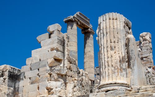 Free Explore ancient Greek architectural ruins with massive columns against a clear blue sky. Stock Photo