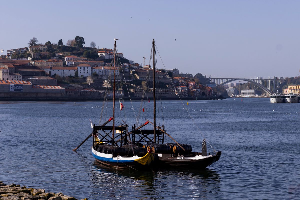 Râul Douro cu bărci rabelo tradiționale și podul Arrábida la Porto
