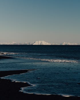 Stunning winter seascape of Kamchatka's snow-capped volcanoes at sunset.