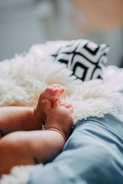Free Baby in Blue Shorts Lying on White Fur Textile Stock Photo