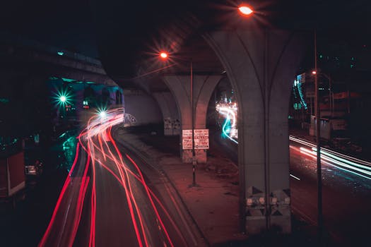 City night scene with vibrant light trails under the highway overpass, creating a dynamic urban atmosphere.