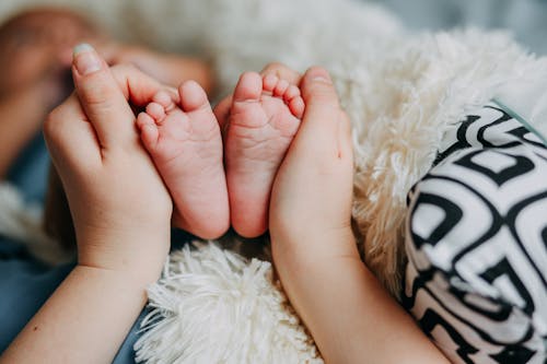 Person Holding Baby's Feet