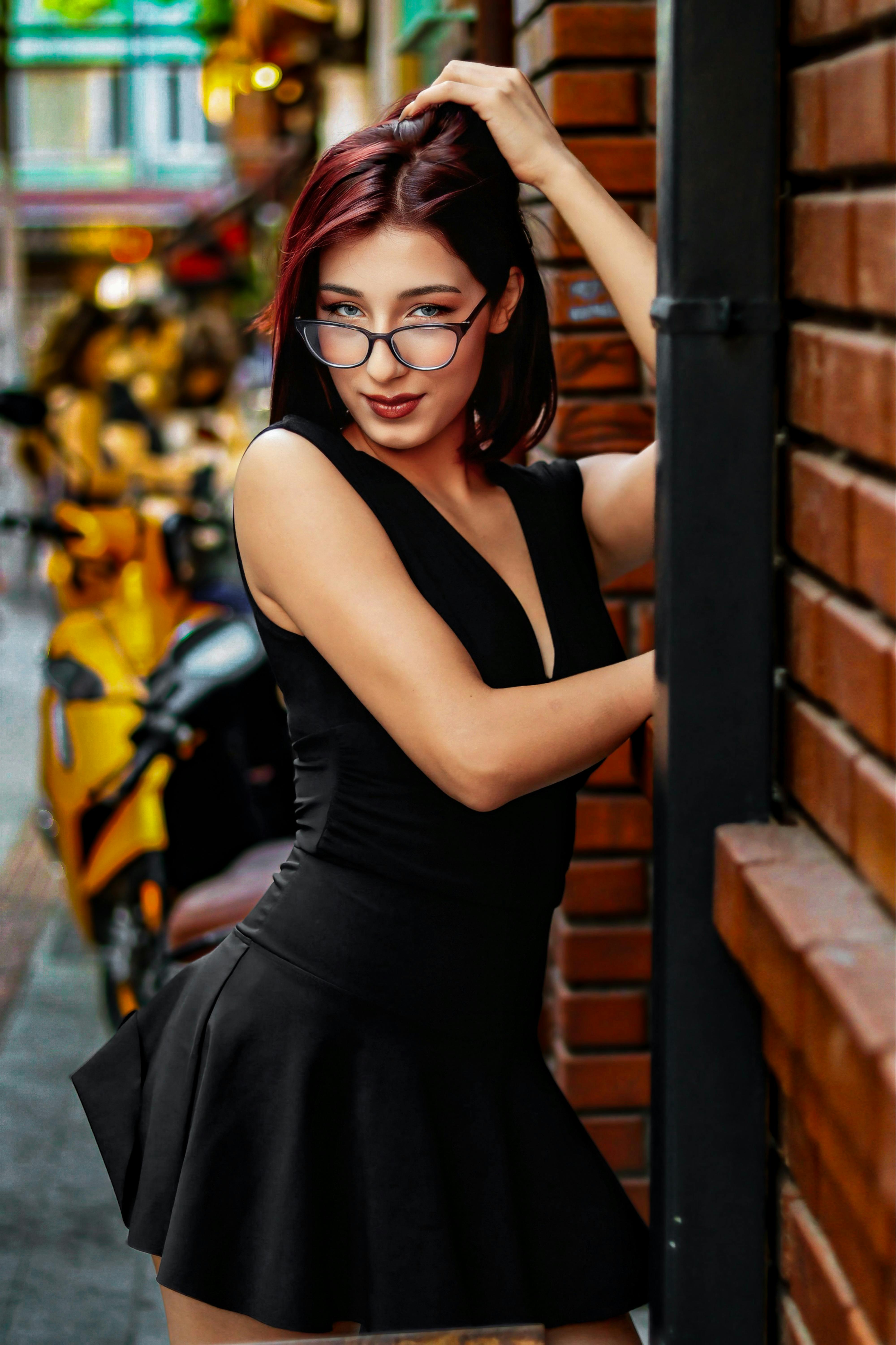 bezplatná Elegantní žena pózující v módním oblečení, vyzařující městskou eleganci v rušné uličce. Základová fotografie