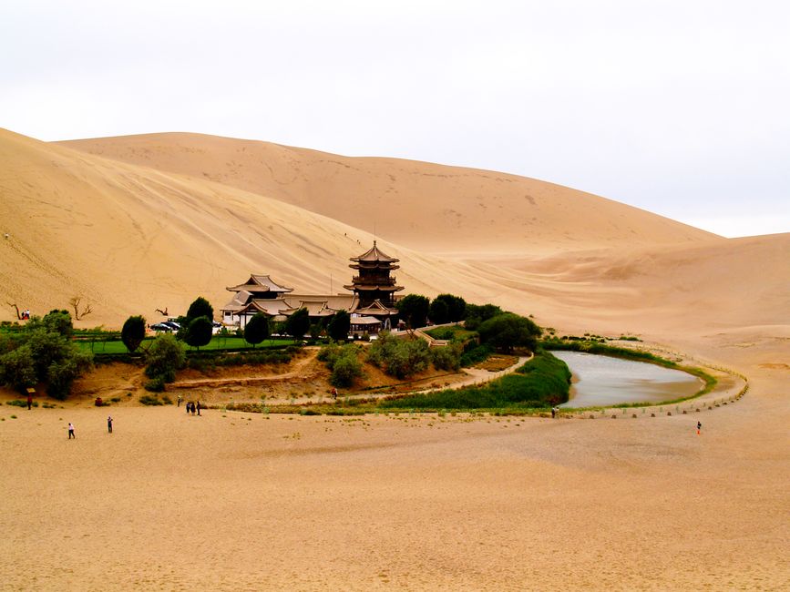 The crescent-shaped lake of Yueyaquan nestled in the sand dunes of Mingsha Mountain at sunset
