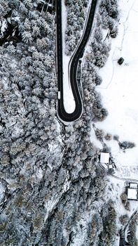 Snow-covered road winding through Saas-Fee, Switzerland, captured in winter from above.