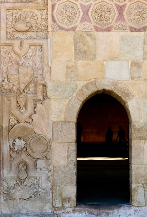 Free Detailed stone archway with intricate carvings, revealing interior silhouettes. Stock Photo