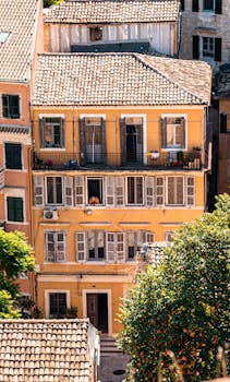Charming view of a sunlit building facade in Corfu, Greece, highlighting the Mediterranean style.