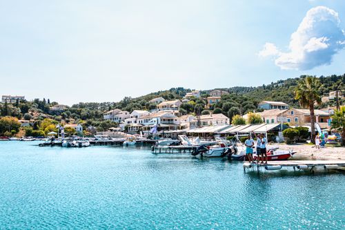Free Beautiful view of azure waters, boats, and traditional Mediterranean architecture in Korfu, Greece. Stock Photo