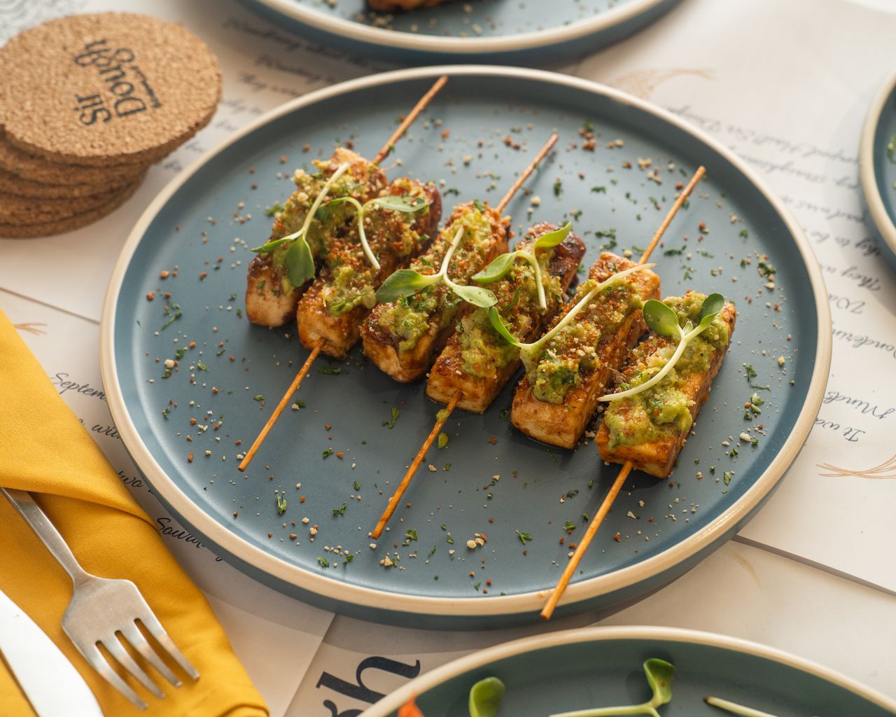 Grilled tofu skewers garnished with microgreens