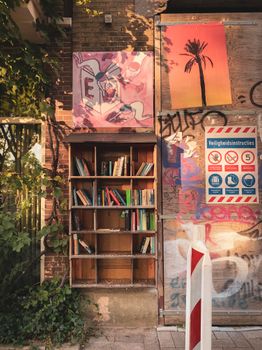 Colorful urban library in Amsterdam with books and graffiti art on a sunny day.