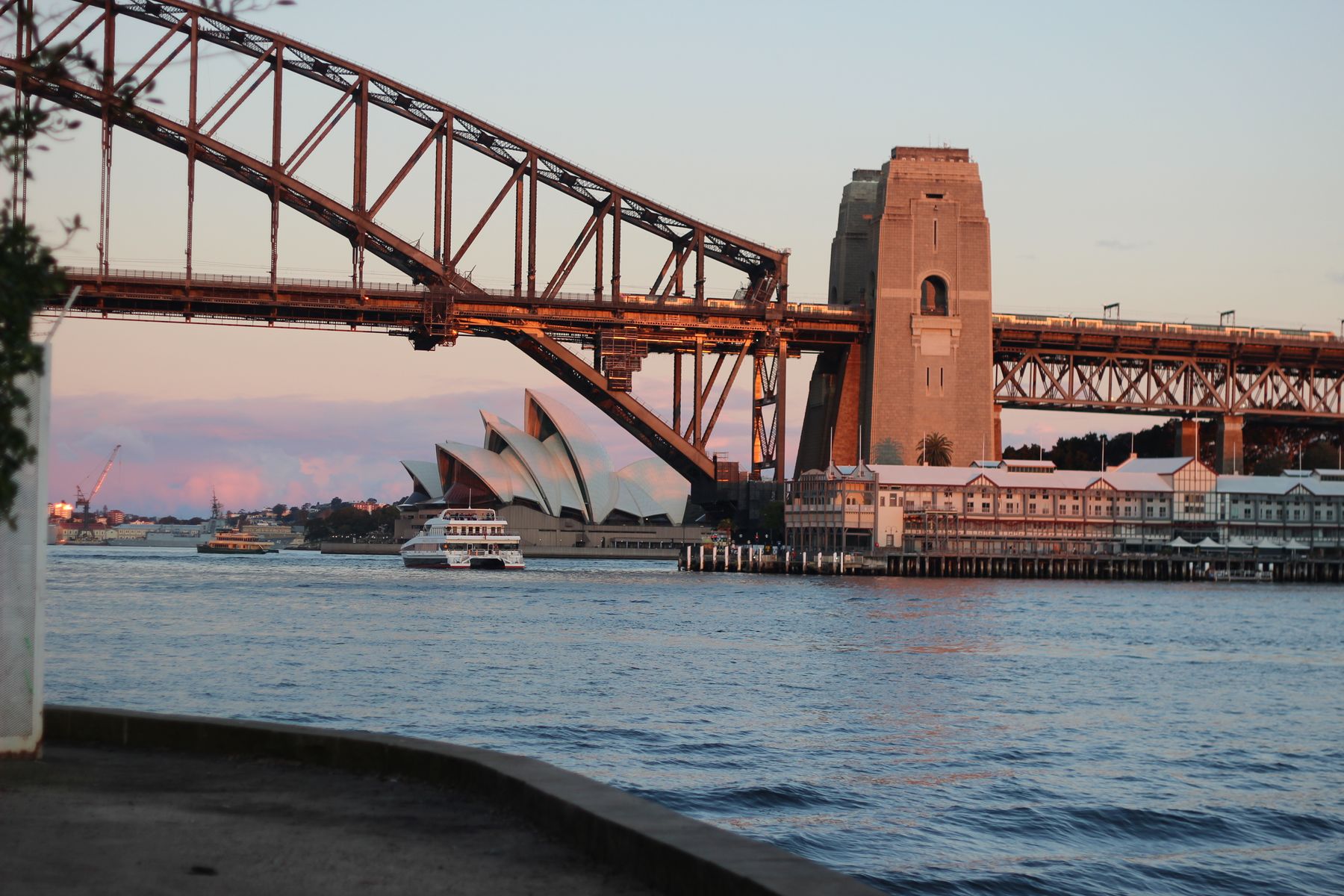 Sydney Harbour ferry passing the Opera House and Harbour Bridge in warm sunset light
