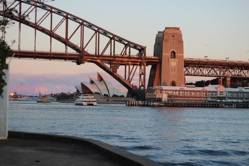 Free Stunning view of Sydney Harbour Bridge and Opera House with ferry during sunset lighting. Stock Photo