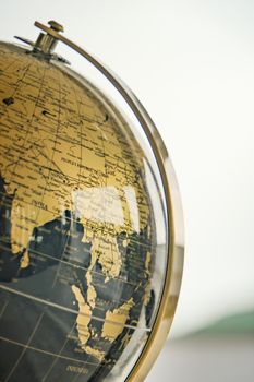 A stylish close-up of a golden-colored vintage earth globe highlighting Asia. 33415524