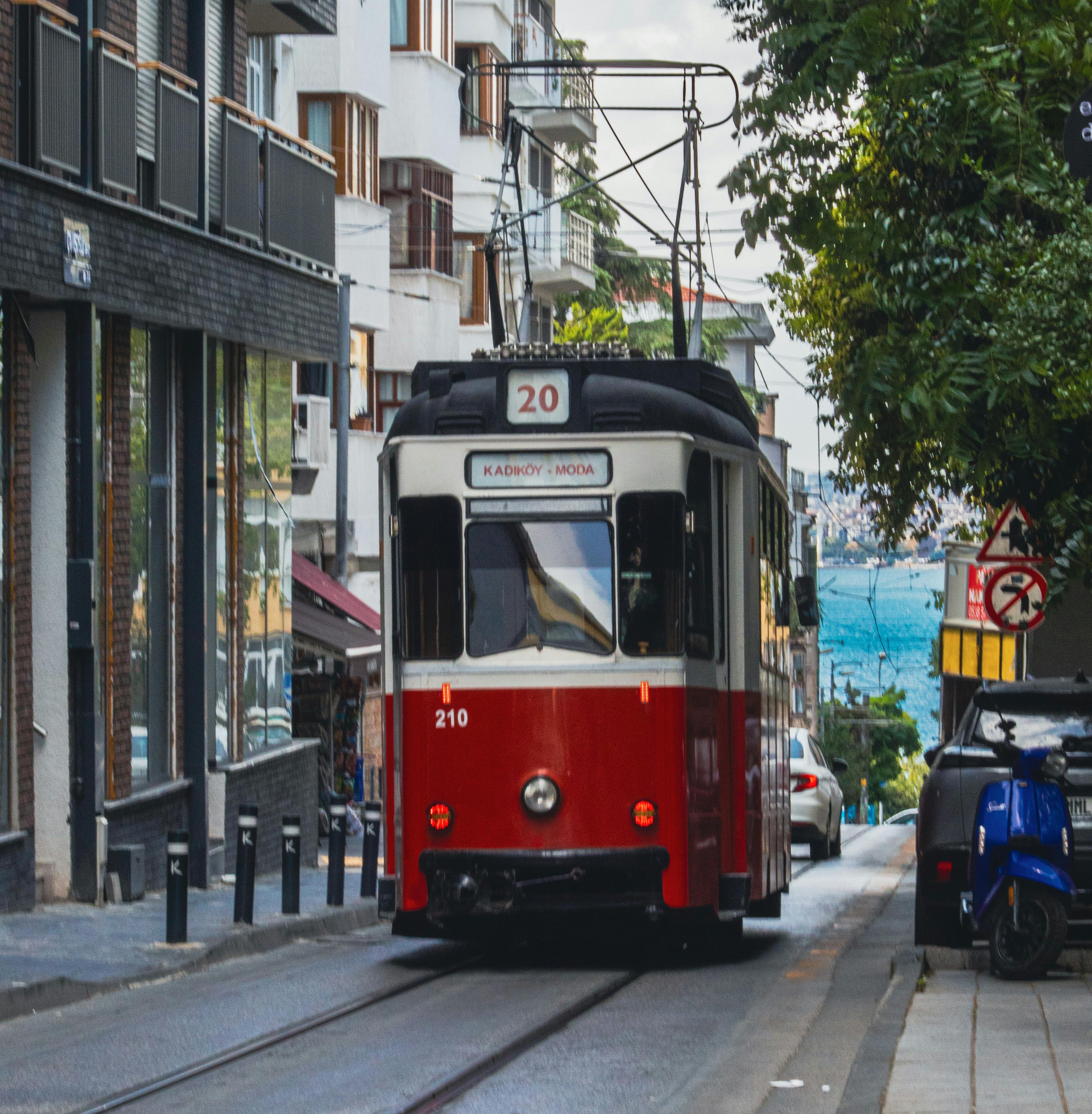 bezplatná Klasická červená tramvaj projíždějící pulzující istanbulskou ulicí bohatou na místní architekturu. Základová fotografie