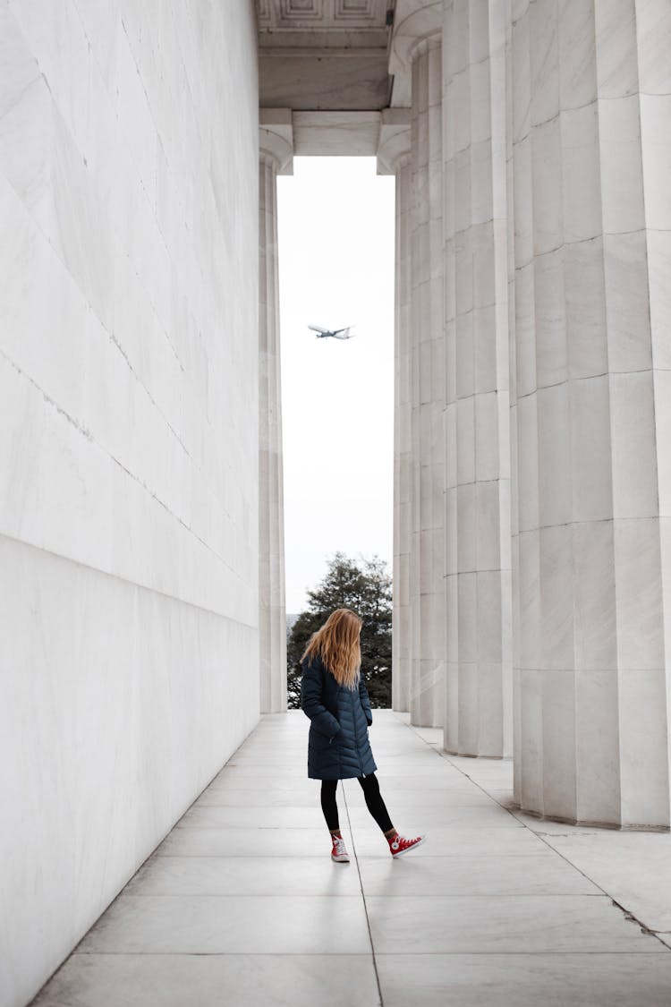 Woman Standing Near Marble Pillars