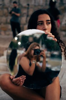 Artistic outdoor photo featuring a reflective mirror and camera handling.