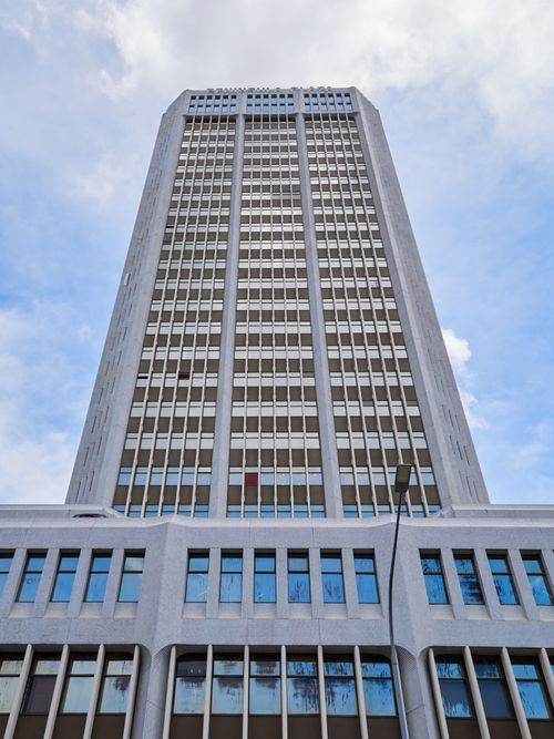 Free A towering modern skyscraper rises against a bright blue sky, showcasing urban architecture. Stock Photo