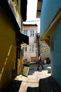 A man walks through a colorful alley, capturing the essence of Bursa's historic charm.