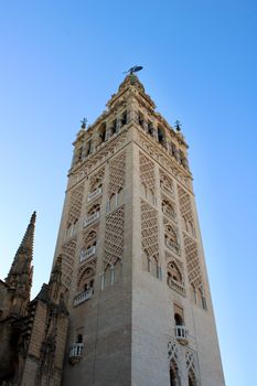 Stunning view of the Giralda Tower in Seville, Spain against a clear blue sky. Iconic architectural landmark.
