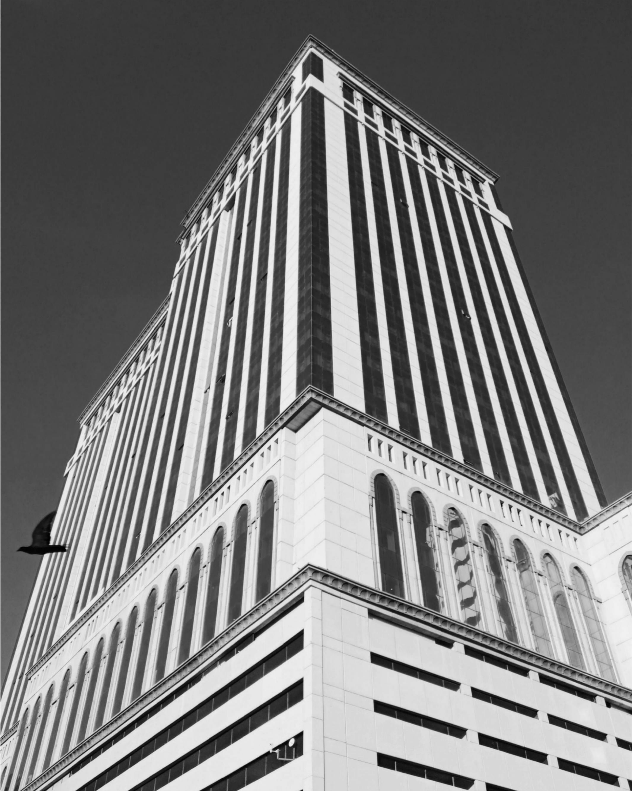 Kostenlos Moderner schwarz-weißer Wolkenkratzer vor klarem Himmel, der architektonische Pracht zur Schau stellt. Stock-Foto