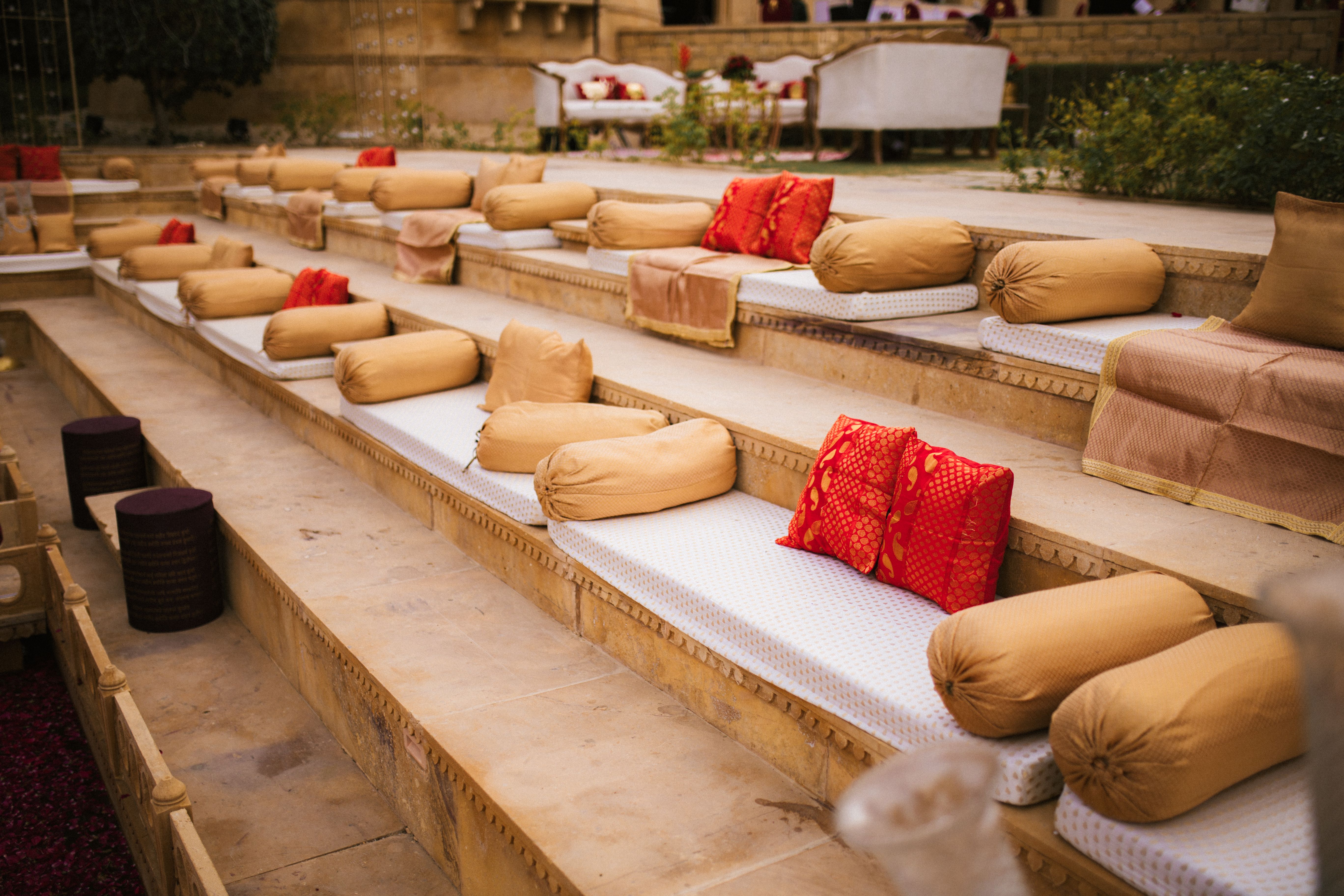 Espaço de lounge ao ar livre decorado com almofadas e tapetes, ideal para eventos ou momentos de descanso em um ambiente aconchegante.