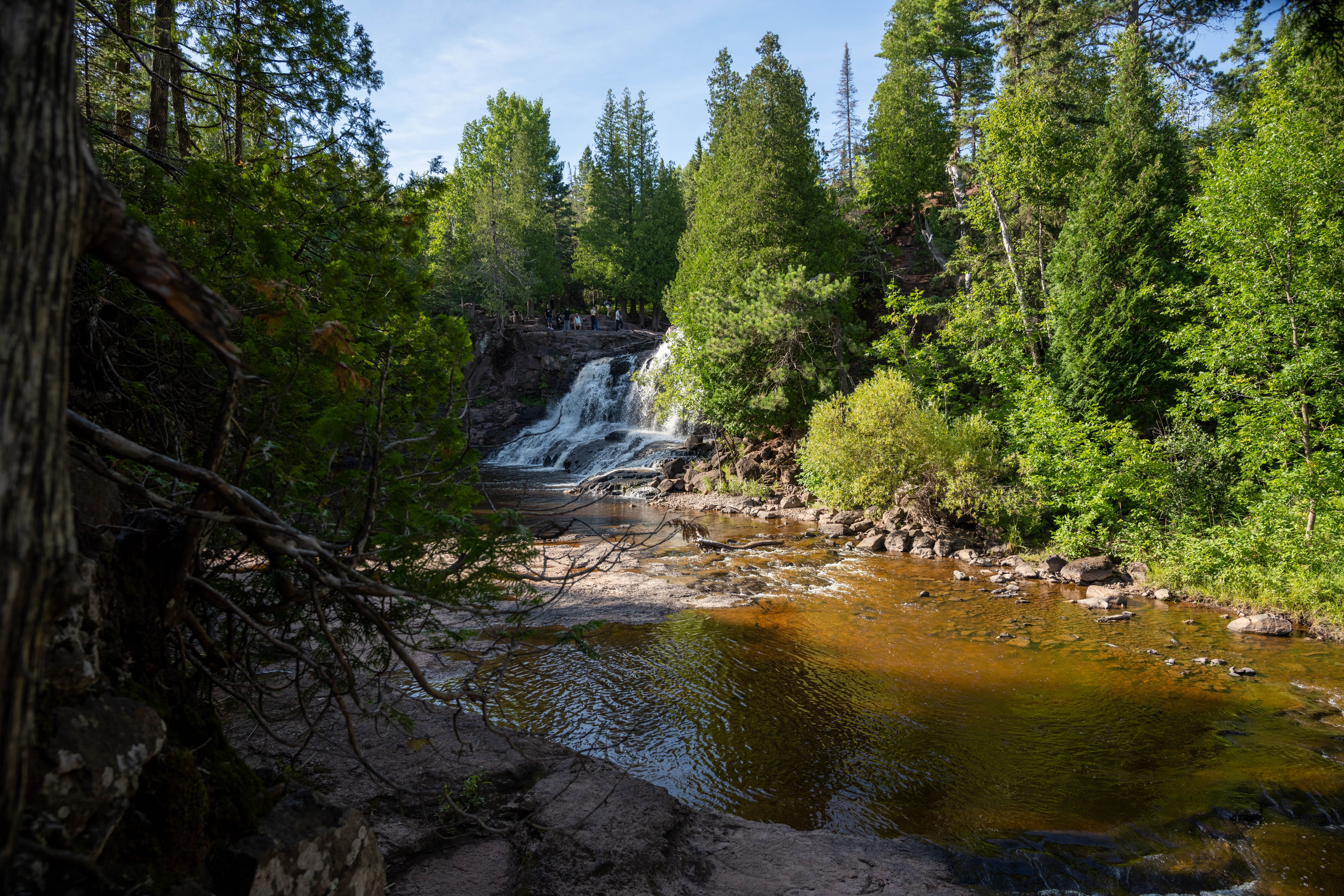 Pemandangan air terjun yang tenang dikelilingi oleh hutan hijau subur di Duluth, Minnesota.