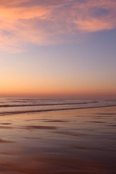 Beautiful sunset over Lacanau Beach in Nouvelle-Aquitaine, France, reflecting vivid colors on the waves.