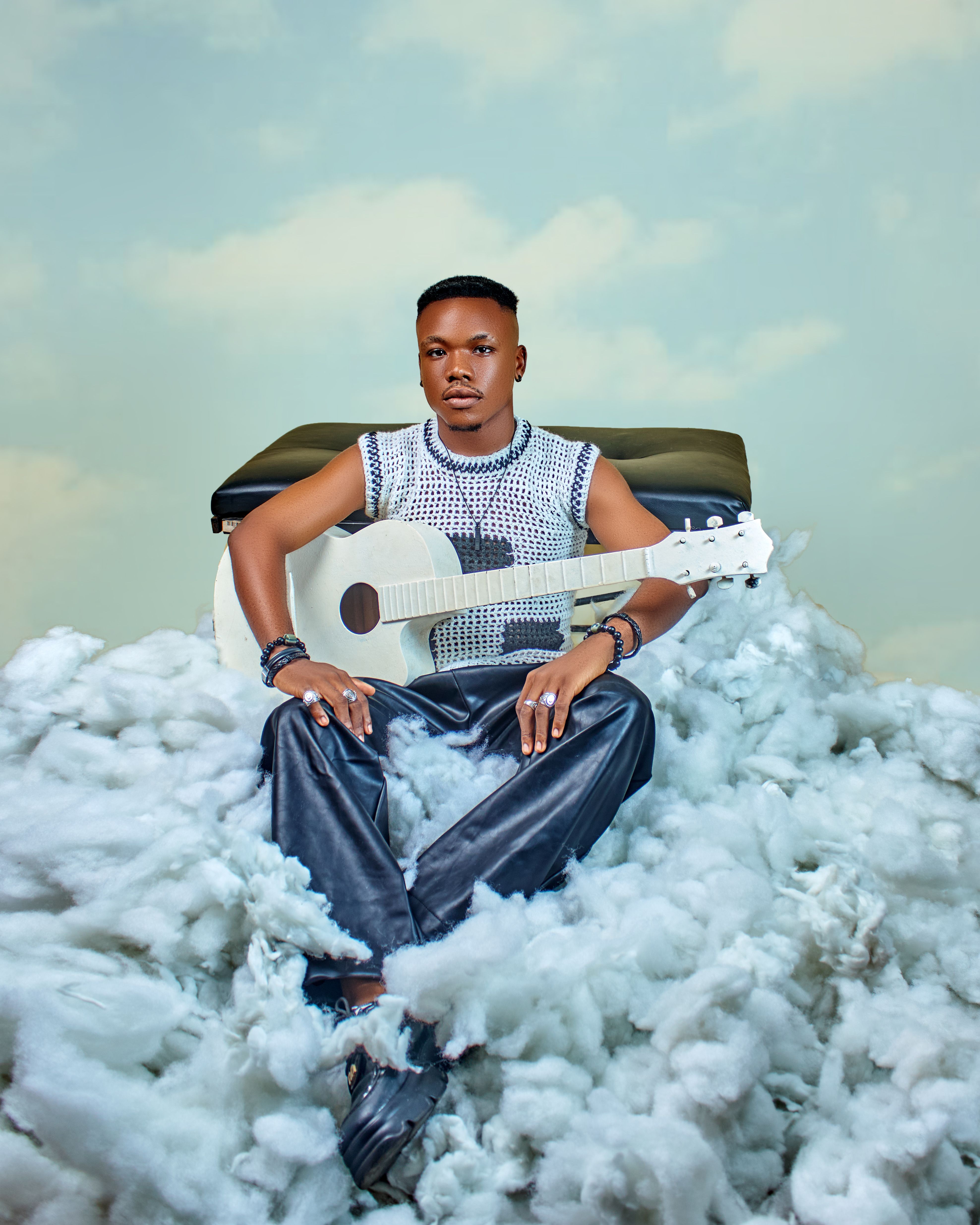 A trendy musician sits on a cloud with a white guitar, creating a dreamy atmosphere.