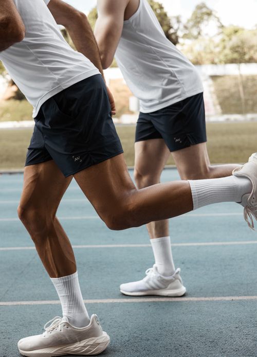 Free Capture the energy of runners in mid-stride on an athletic track in daylight. Stock Photo