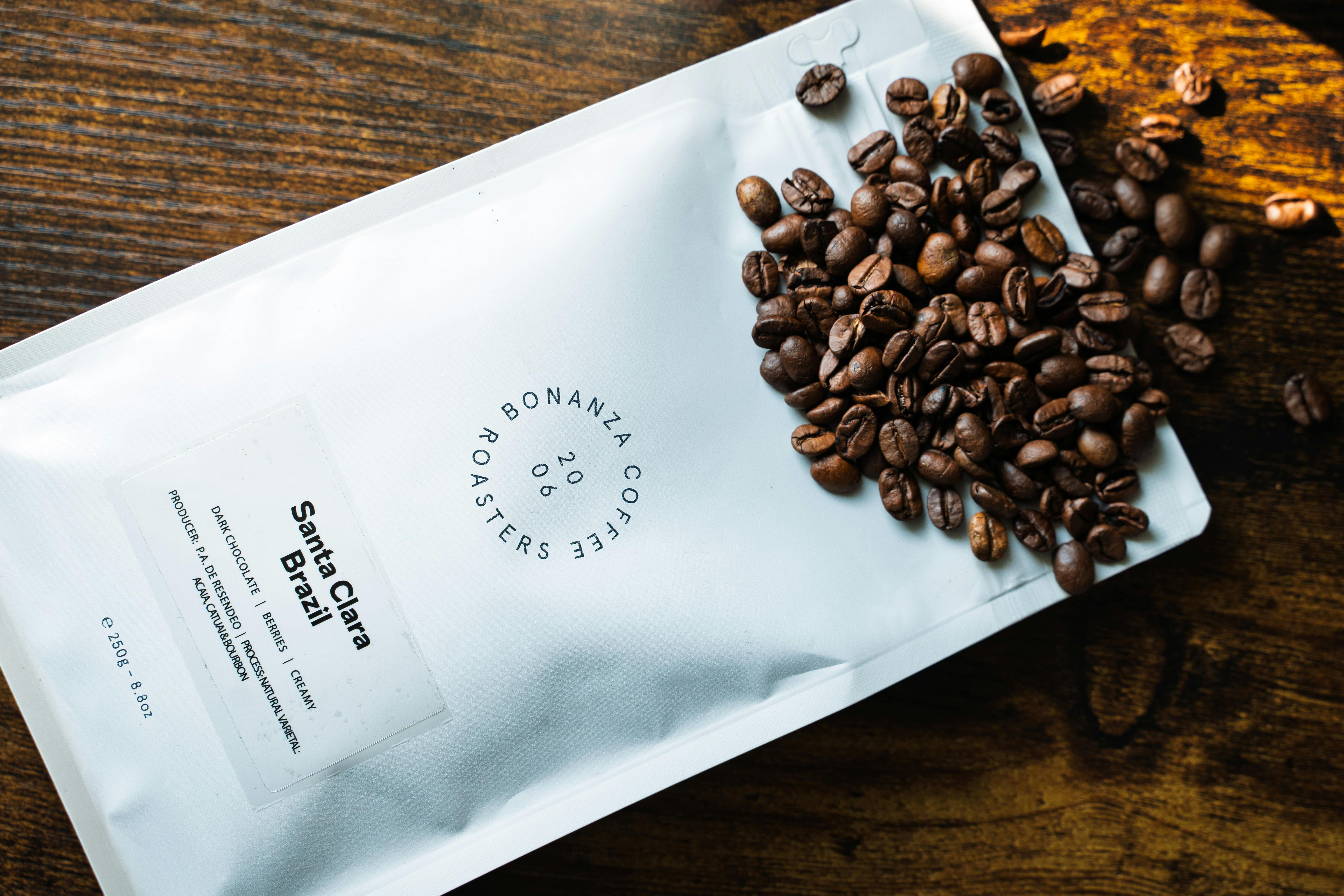 premium vanilla coffee beans for sale - Discover the rich aroma of Bonanza Coffee's Santa Clara Brazilian roasted beans, artfully presented on a wooden table.