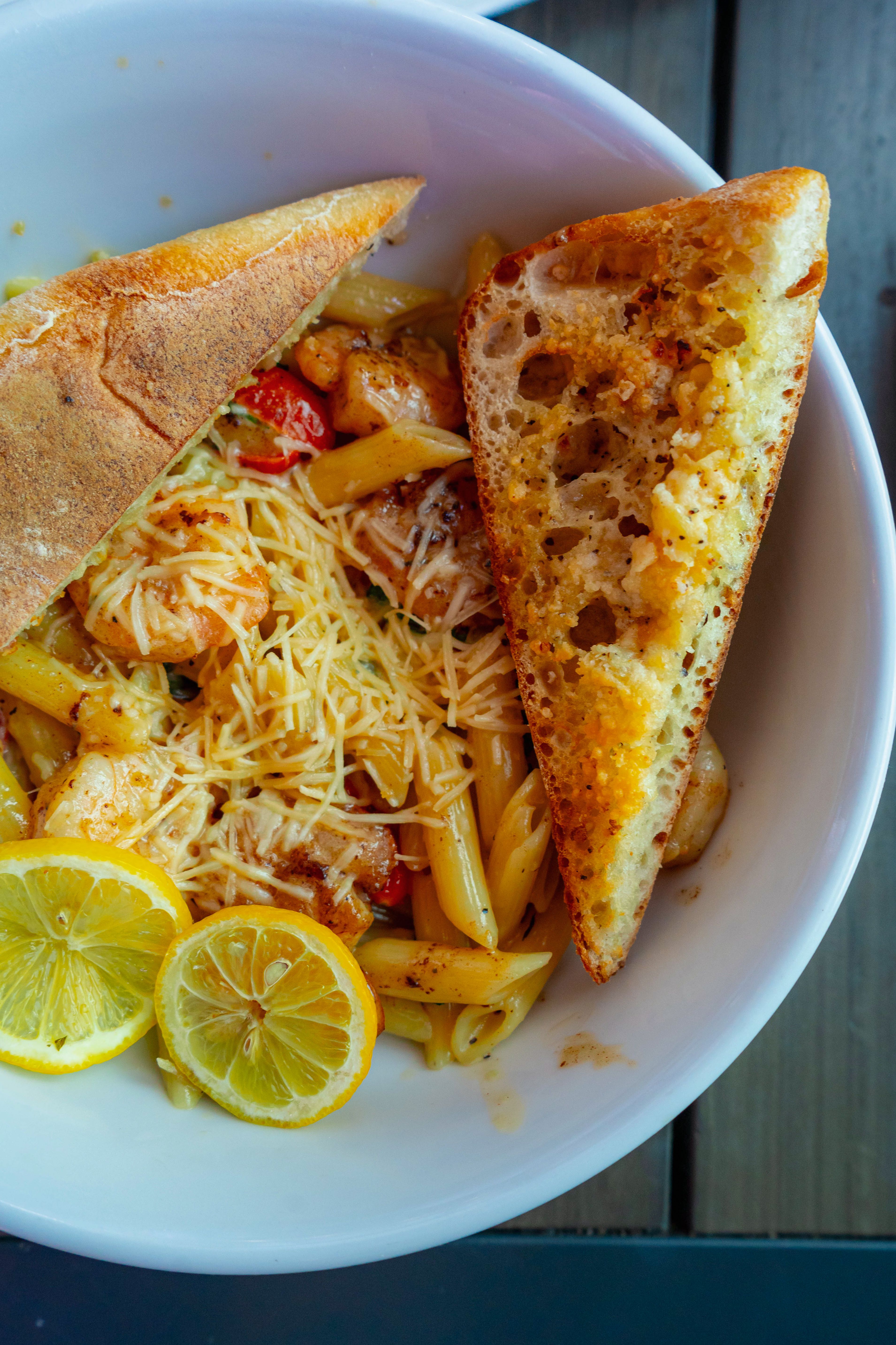 Delicious gourmet pasta with garlic bread and lemon slices served in a Denver restaurant.