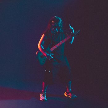 Vibrant performance by a guitarist with colorful stage lighting in Hà Nội.