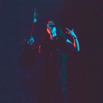A cool musician poses with an electric guitar under vibrant lighting, capturing the essence of rock.