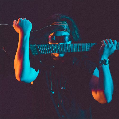 Free Portrait of a musician with an electric guitar, captured in neon lighting in Hà Nội. Stock Photo